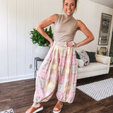Lightweight cotton balloon style pants with elastic waist and cuffs, side pockets and pastel taupe, pink and coral paisley bandana print.
