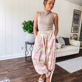 Lightweight cotton balloon style pants with elastic waist and cuffs, side pockets and pastel taupe, pink and coral paisley bandana print.