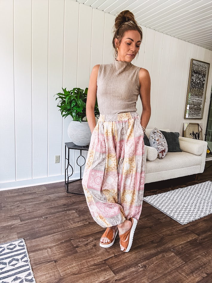 Lightweight cotton balloon style pants with elastic waist and cuffs, side pockets and pastel taupe, pink and coral paisley bandana print.