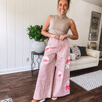 Lightweight blush and cream pinstripe ultra wide leg pants with oversized rose appliques throughout, button and zipper closure with elastic back at the waist, side and back pockets.