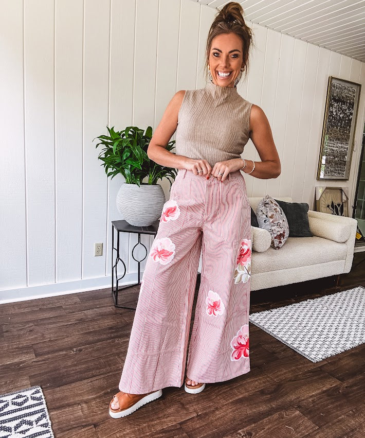 Lightweight blush and cream pinstripe ultra wide leg pants with oversized rose appliques throughout, button and zipper closure with elastic back at the waist, side and back pockets.