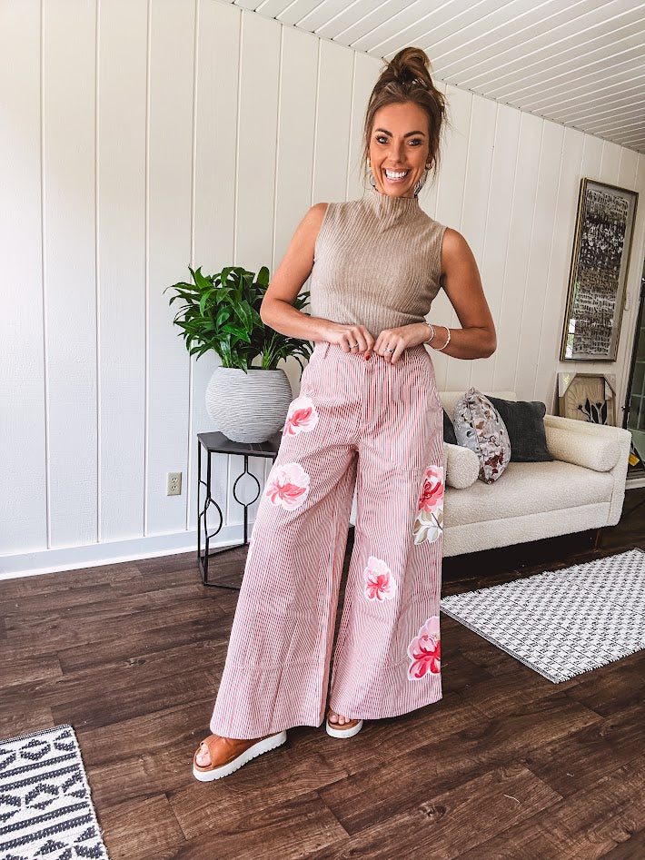 Lightweight blush and cream pinstripe ultra wide leg pants with oversized rose appliques throughout, button and zipper closure with elastic back at the waist, side and back pockets.