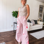 Lightweight blush and cream pinstripe ultra wide leg pants with oversized rose appliques throughout, button and zipper closure with elastic back at the waist, side and back pockets.
