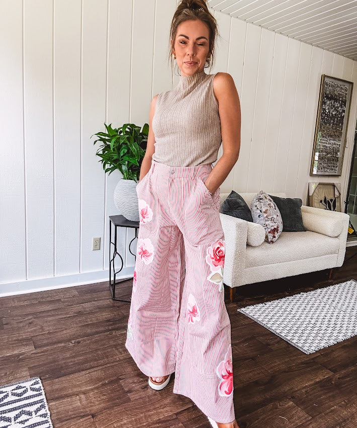 Lightweight blush and cream pinstripe ultra wide leg pants with oversized rose appliques throughout, button and zipper closure with elastic back at the waist, side and back pockets.