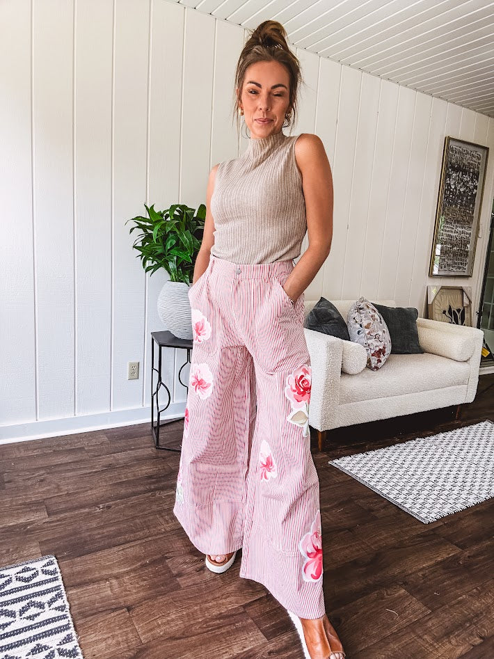Lightweight blush and cream pinstripe ultra wide leg pants with oversized rose appliques throughout, button and zipper closure with elastic back at the waist, side and back pockets.