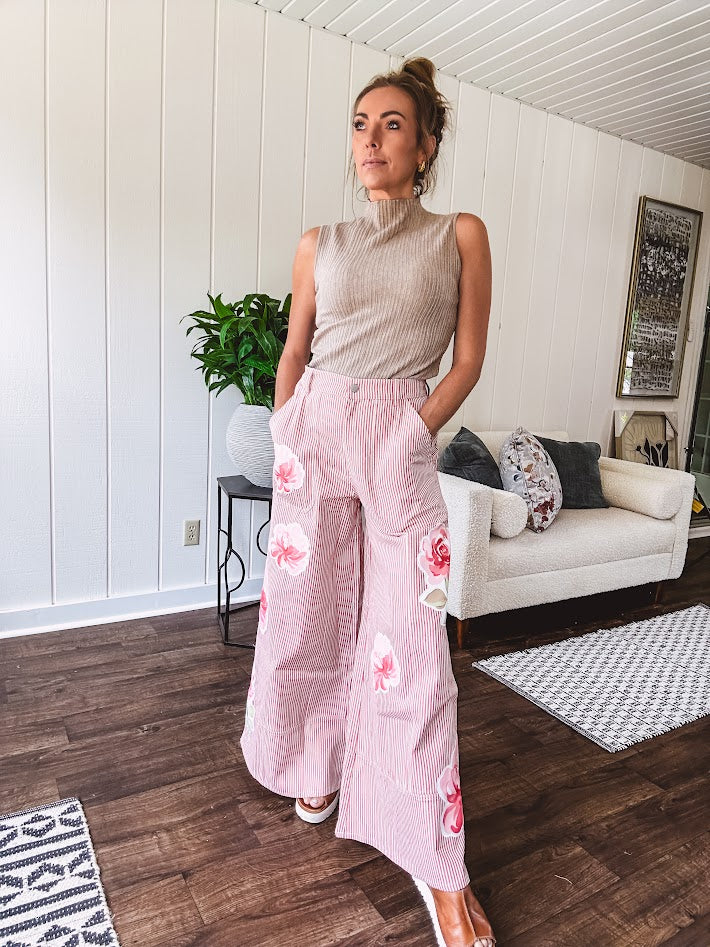 Lightweight blush and cream pinstripe ultra wide leg pants with oversized rose appliques throughout, button and zipper closure with elastic back at the waist, side and back pockets.