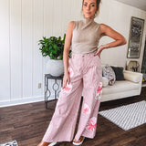 Lightweight blush and cream pinstripe ultra wide leg pants with oversized rose appliques throughout, button and zipper closure with elastic back at the waist, side and back pockets.