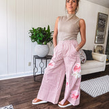 Lightweight blush and cream pinstripe ultra wide leg pants with oversized rose appliques throughout, button and zipper closure with elastic back at the waist, side and back pockets.