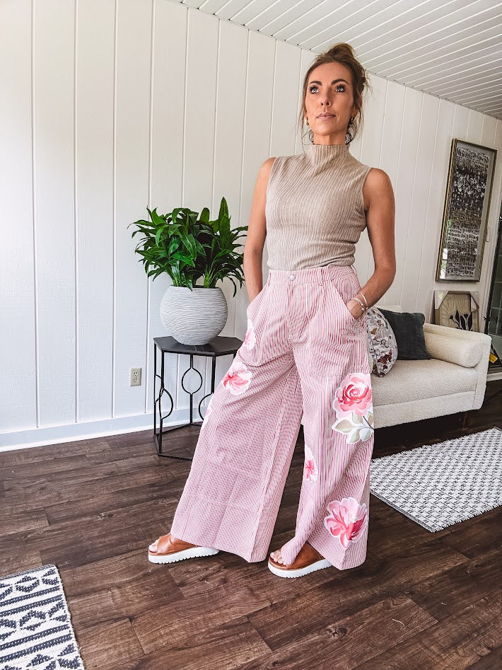 Lightweight blush and cream pinstripe ultra wide leg pants with oversized rose appliques throughout, button and zipper closure with elastic back at the waist, side and back pockets.
