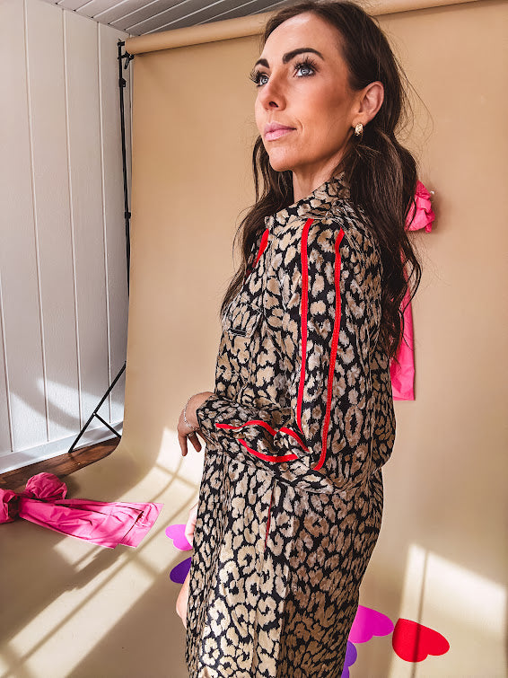 Leo print gold metallic button down dress with red stripes on the sleeves. Metal buttons, a collar, and functional pockets