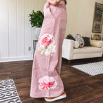 Lightweight blush and cream pinstripe ultra wide leg pants with oversized rose appliques throughout, button and zipper closure with elastic back at the waist, side and back pockets.