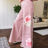 Lightweight blush and cream pinstripe ultra wide leg pants with oversized rose appliques throughout, button and zipper closure with elastic back at the waist, side and back pockets.
