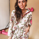Ivory lounge set with pink, blue, and green florals, a quarter-zip top with kangaroo pocket, mock neck, and hi-low hem and matching bottoms with drawstring waist and pockets.