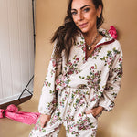 Ivory lounge set with pink, blue, and green florals, a quarter-zip top with kangaroo pocket, mock neck, and hi-low hem and matching bottoms with drawstring waist and pockets.