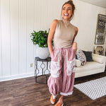 Soft, lightweight cotton pants that blend rose and grey plaid with creamy floral patchwork, lacey cream crochet trim, and a patchwork-trimmed ruffled hemline. Elastic drawstring waist and wide-leg silhouette with lace at the cuffs.