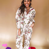 Ivory lounge set with pink, blue, and green florals, a quarter-zip top with kangaroo pocket, mock neck, and hi-low hem and matching bottoms with drawstring waist and pockets.