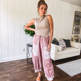 Soft, lightweight cotton pants that blend rose and grey plaid with creamy floral patchwork, lacey cream crochet trim, and a patchwork-trimmed ruffled hemline. Elastic drawstring waist and wide-leg silhouette with lace at the cuffs.
