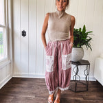 Soft, lightweight cotton pants that blend rose and grey plaid with creamy floral patchwork, lacey cream crochet trim, and a patchwork-trimmed ruffled hemline. Elastic drawstring waist and wide-leg silhouette with lace at the cuffs.