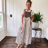 Brown washed denim overall top with silver metal hardware and adjustable straps and a cream and brown striped, lightweight skirt with pockets.
