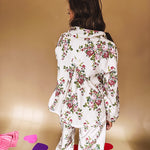 Ivory lounge set with pink, blue, and green florals, a quarter-zip top with kangaroo pocket, mock neck, and hi-low hem and matching bottoms with drawstring waist and pockets.