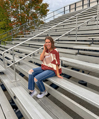 Red brown and cream striped sweatshirt with oversized dolman cut, short sleeves and a gingham football applique trimmed in cream lace.