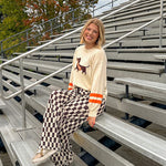 Cream lightweight long sleeved sweater with Weiner Dog graphic on front with orange stripes at the sleeves.