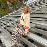 Cream lightweight long sleeved sweater with Weiner Dog graphic on front with orange stripes at the sleeves.