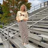 Cream lightweight long sleeved sweater with Weiner Dog graphic on front with orange stripes at the sleeves.