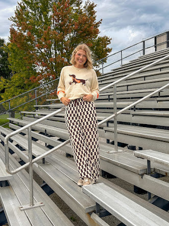Cream lightweight long sleeved sweater with Weiner Dog graphic on front with orange stripes at the sleeves.