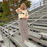 Cream lightweight long sleeved sweater with Weiner Dog graphic on front with orange stripes at the sleeves.