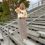 Cream lightweight long sleeved sweater with Weiner Dog graphic on front with orange stripes at the sleeves.