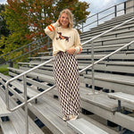 Cream lightweight long sleeved sweater with Weiner Dog graphic on front with orange stripes at the sleeves.
