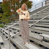 Cream lightweight long sleeved sweater with Weiner Dog graphic on front with orange stripes at the sleeves.