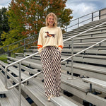 Cream lightweight long sleeved sweater with Weiner Dog graphic on front with orange stripes at the sleeves.