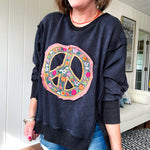 Washed charcoal pullover with exposed seams, a coral and floral peace patch on the front and split front hem.