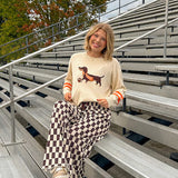 Cream lightweight long sleeved sweater with Weiner Dog graphic on front with orange stripes at the sleeves.