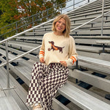 Cream lightweight long sleeved sweater with Weiner Dog graphic on front with orange stripes at the sleeves.