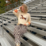 Cream lightweight long sleeved sweater with Weiner Dog graphic on front with orange stripes at the sleeves.