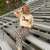 Cream lightweight long sleeved sweater with Weiner Dog graphic on front with orange stripes at the sleeves.