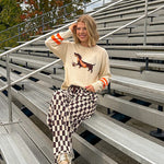 Cream lightweight long sleeved sweater with Weiner Dog graphic on front with orange stripes at the sleeves.