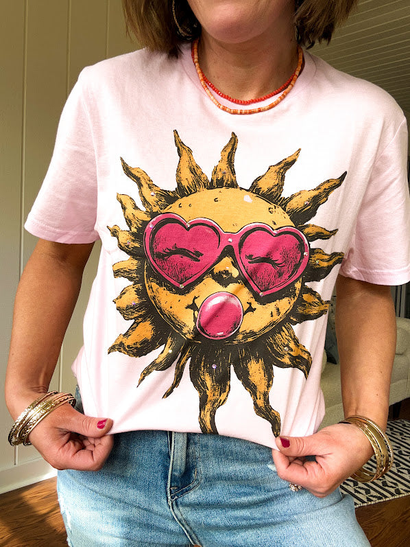 Bubble gum pink cotton tee with large orange sun with a face, pink sunglasses and bubble gum graphic.