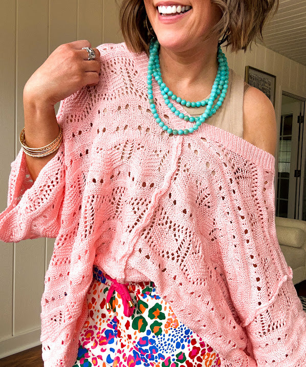 Soft, woven wide V neck sweater with 3/4 sleeves and a seashell design in the weave with exposed seams down the middle and at the shoulders. Oversized
