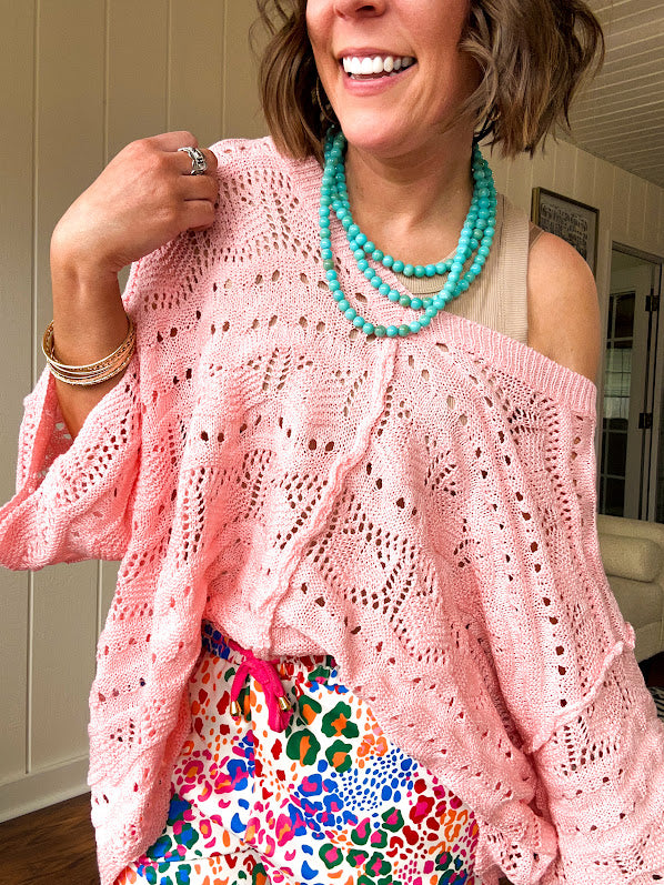 Soft, woven wide V neck sweater with 3/4 sleeves and a seashell design in the weave with exposed seams down the middle and at the shoulders. Oversized