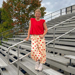 Soft, stretchy cream elastic drawstring waist pants with large red polka dots throughout, pockets and button cuffs for a balloon-like silhouette.