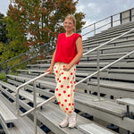 Soft, stretchy cream elastic drawstring waist pants with large red polka dots throughout, pockets and button cuffs for a balloon-like silhouette.