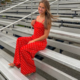 Red jumpsuit with white polka dots throughout, adjustable, removable spaghetti straps, wide leg design and cutout at the back.