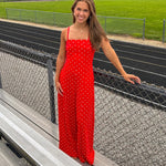 Red jumpsuit with white polka dots throughout, adjustable, removable spaghetti straps, wide leg design and cutout at the back.