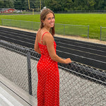 Red jumpsuit with white polka dots throughout, adjustable, removable spaghetti straps, wide leg design and cutout at the back.