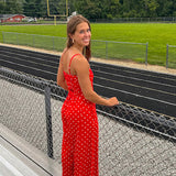 Red jumpsuit with white polka dots throughout, adjustable, removable spaghetti straps, wide leg design and cutout at the back.