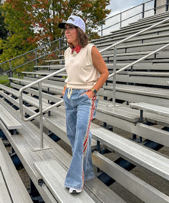 Light wash denim-like wide leg pants with leo and red striping down the sides and elastic, drawstring waist.